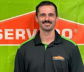 Male employee with black shirt and orange and green background