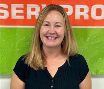 Female employee with brown hair and orange and green background.