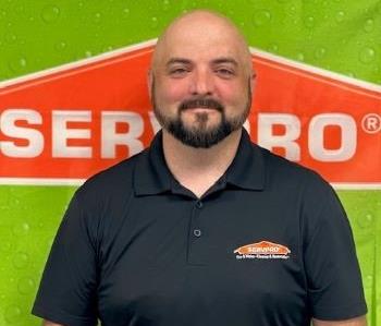 Male employee with black shirt and green and orange background