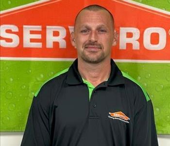 Male employee with black shirt and green and orange background