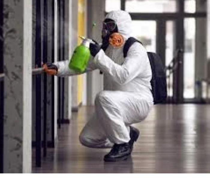 wall with guy in white suit and green spray bottle